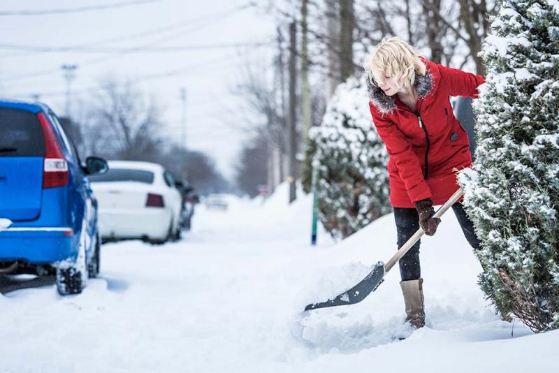 woman shoveling her driveway